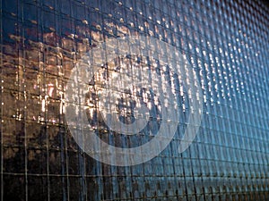 Close up of reinforced wired glass with an vague outdoor reflection - Selective focus