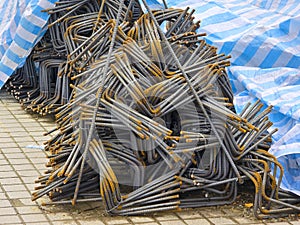 close up Reinforcing bars placed on the ground in the construction site, covered with rainproof cloths.