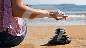 Close Up Of Relaxed Woman Stacking Stones On Peaceful Beach Vacation