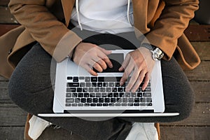 Close-up of relaxed young man using laptop outdoor. Freelance.