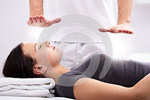 Young Woman Receiving Reiki Treatment By Therapist photo