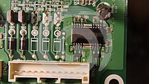 A close-up of the removal of the chip from the green electronic board with a soldering station. The brazing flux is boiling under