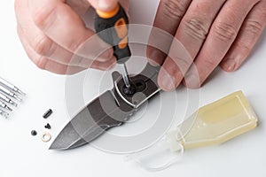 Close-up on repairman`s hands assembling the parts of a pocket knife