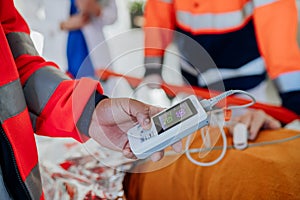 Close-up of rescuers taking care of patient from ambulance, checking oximeter. photo
