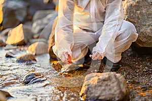 Close-up of researcher collecting water sample at seashore