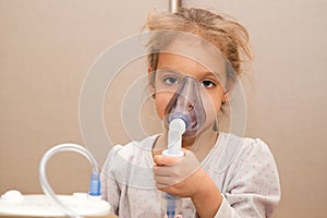 Close up. Respiratory diseases. A 5-year-old child inhales medication using a nebulizer. Therapy of coronavirus