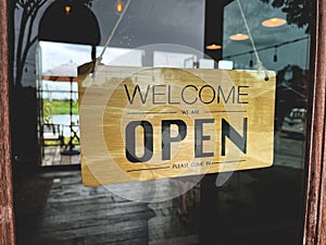 Close up of restaurant worker turning Open sign to reopen the cafe to welcome customer.