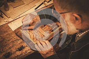 Close-up of restorer hands working with antique decor element in his workshop