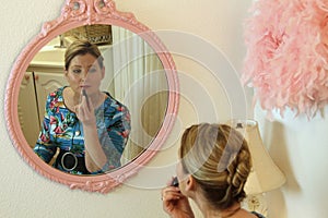 Close up of Retro woman sitting on bathroom vanity bench putting on makeup and preparing to go out