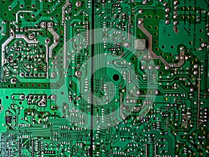 A close-up reveals the intricacies of a green computer circuit board, with various silver and gold components adorning its surface