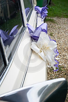 A Close Up Of Ribbons Attached To A Vintage Wedding Car
