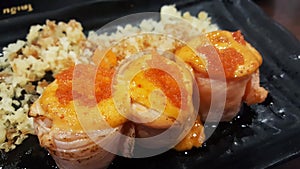 Close up rice wrapped in bacon top up with shrimp roe