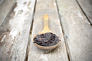 Close up of riceberry in spoon on old wooden