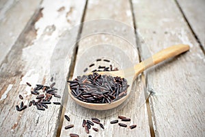 Close up of riceberry in spoon on white wooden