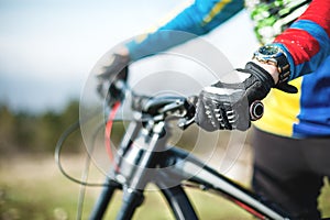 Close-up of a rider`s hand in gloves on a mountain bike handlebars