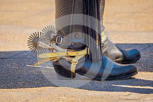 Close up of riding spurs with sharp spikes rowel on authentic western cowboy traditional leather boots on old aged in a