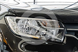 Close-up of right headlight of dark gray Renault Sandero Stepway car at Renault