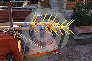 Close-up of rightly colored olive picking tools sticking out of the back of a scratched and grungy truck bed parked in a small