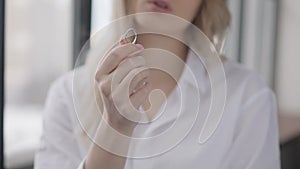 Close-up of ring in female Caucasian hand with blurred unrecognizable young woman sighing at background. Stressed