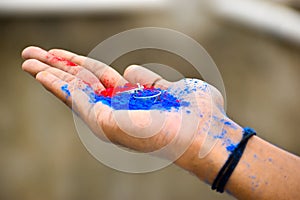 Close up of ring jewelry on human hand with vibrant holi multi colors powder. Selective focus on friendship ring. Happy festival