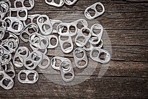 Close up rings pull aluminum of soda or beer can isolate on wood background.