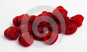 Close up of ripe red raspberries on white surface, no people