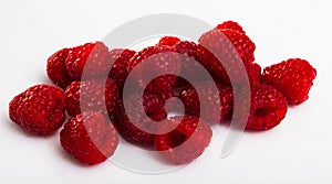 Close up of ripe red raspberries on white surface, no people