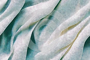 Close-up of rippled white natural fur silk fabric texture background. Suede leather chamois delicate fabric textile