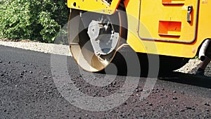 Close-up, Road construction works with roller compactor machine and asphalt finisher. Road roller laying fresh asphalt