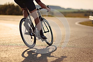 Close up of road cyclist with strong legs biking outdoor