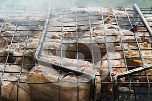 close-up: roast porkmeat inside grill on fire with smoke