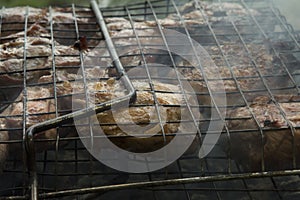 close-up: roast porkmeat inside grill on fire with smoke