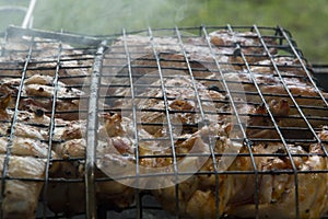 close-up: roast porkmeat inside grill on fire with smoke