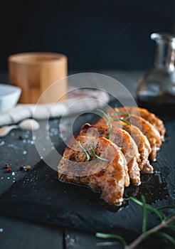 Close-up of roasted pork chops with fresh rosemary on dark background