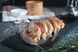 Close-up of roasted pork chops with fresh rosemary on dark background