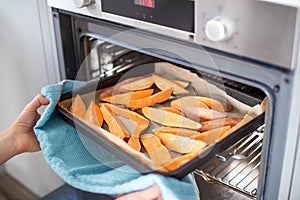 Close Up Of Roasting Tray Of Sweet Potato Wedges In Oven