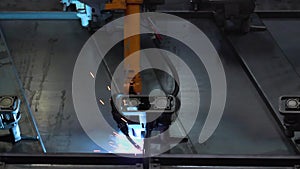 Close up robot welding in factory. Scene. Industrial orange robot welder conduct welding of metal parts. Close-up