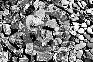 Close-up in the rock garden with round river pebbles and sharp-edged gravel in black and white