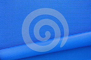 Close up roll blue color yoga mat texture background, top view, copy space, healthy lifestyle, sport and exercise concept