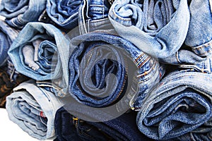Close up rolled of blue jeans pants, dark blue denim trousers showing texture on white