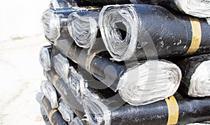 Close-up of rolls of new black roofing felt or bitumen that is precisely folded