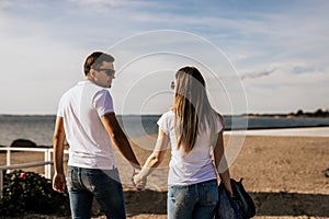 Close up of romantic couple hold hands and walk on the beach