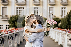 Close up of romantic couple are kissing in embrance with building on background