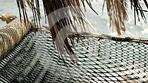 Close up of romantic cozy empty hammock with tropical ocean on the background. Vacation to paradise, travel to the sea