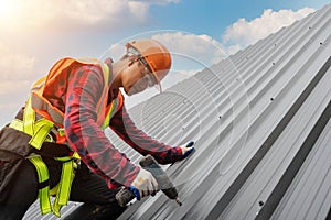 Close up roofer installing metal sheet and wear safety uniform working on high