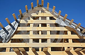 A close-up on roofing construction, gable roof framing using roof beams, rafters, trusses, braces, eaves and damp proof barrier