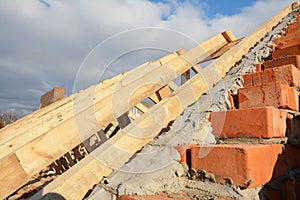 A close-up on a roofing construction, trusses and roof beams installation on a brick wall of the house