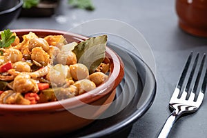 Close up. Ropa vieja, typical Canarian dish of chickpeas stew on earthenware casserole on dark base