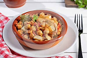 Close up. Ropa vieja, typical Canarian dish of chickpeas stew on earthenware casserole on white table photo