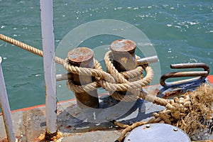 Close up of ropes and rusty bollard. rope and Marina bollard on moorage. Nautical mooring rope. The concept of mooring and water